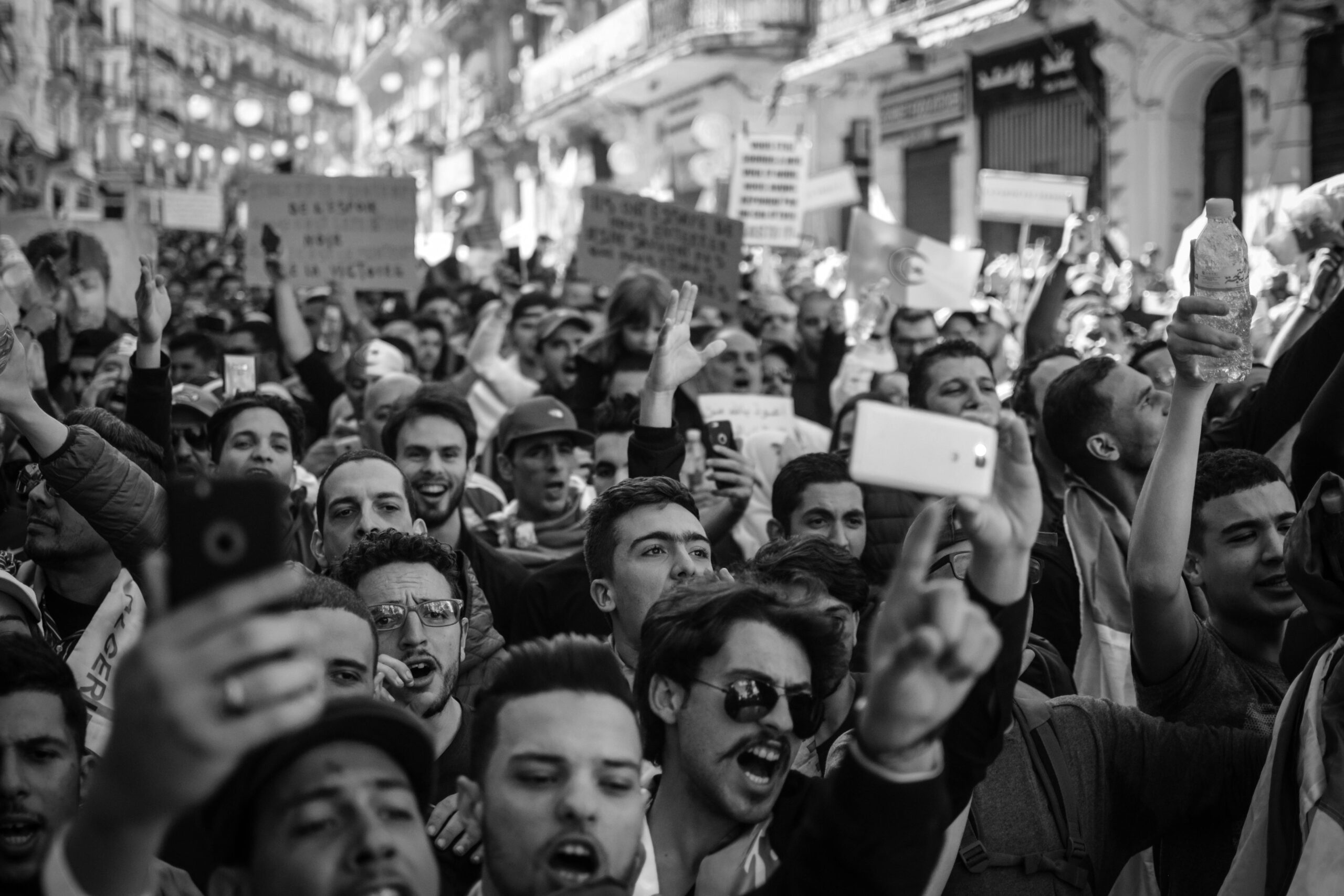 Crowded Algerian street protest captured with intensity and detail.